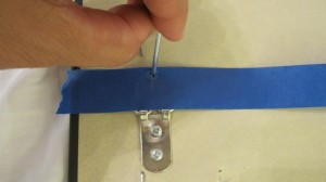 Step 2 Punch a nail hole through the tape Step 2 Punch a nail hole through the tape - this will be your guide for hanging